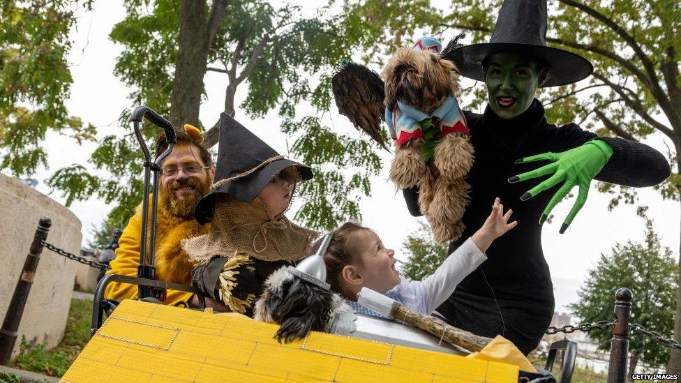 A family and two dogs dressed as characters from the wizard of oz