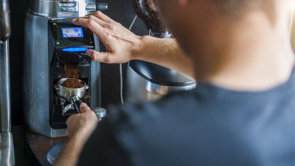 A barista makes a coffee