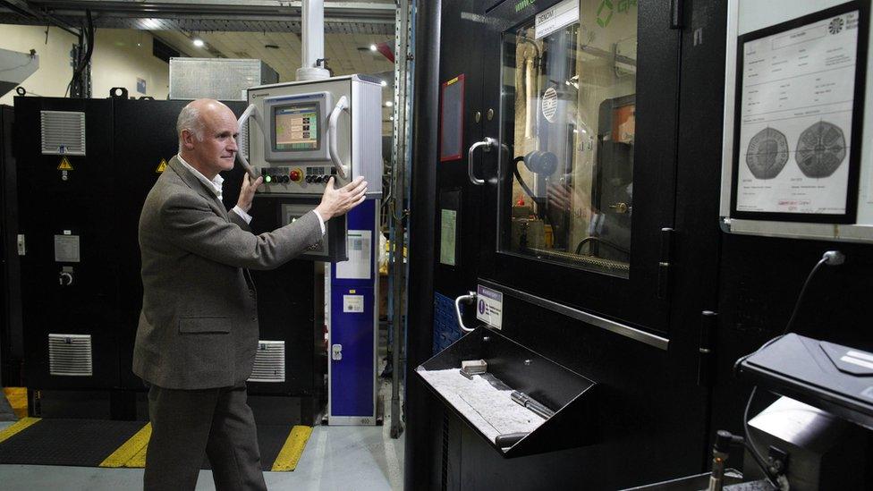 Artist Martin Jennings prepares the first coins featuring King Charles III to be struck