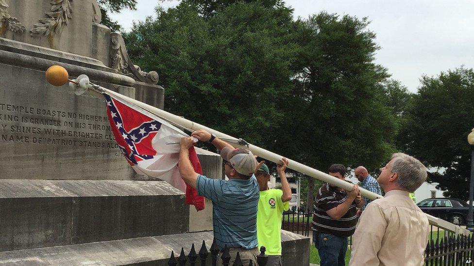 State workers take down a Confederate national flag on the grounds of the state Capitol, Wednesday, June 24, 2015, in Montgomery, Ala.