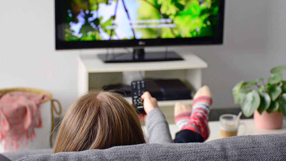 Woman watching TV with subtitles