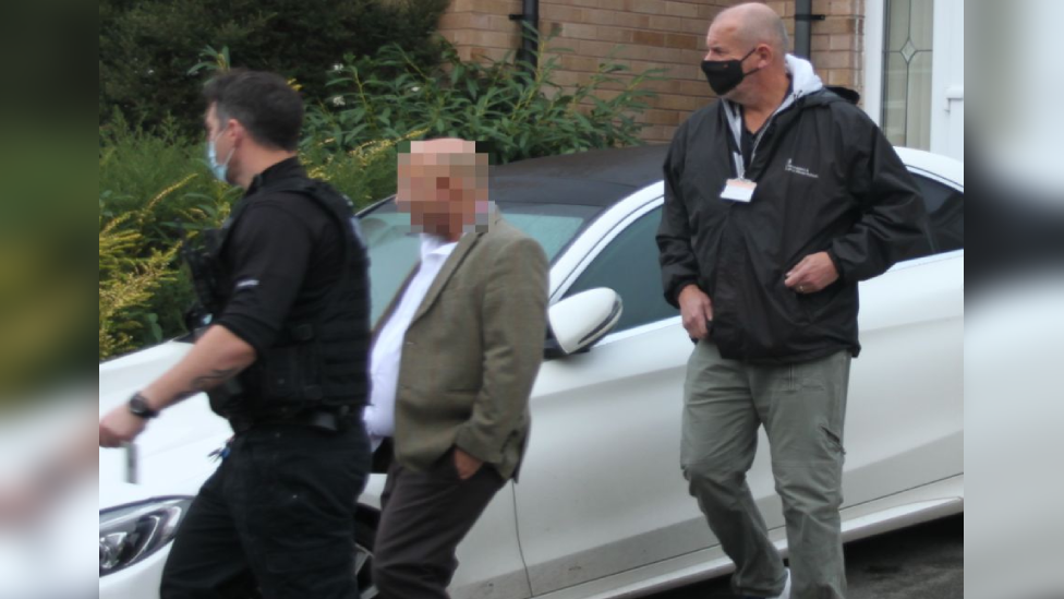 GLAA officers and an arrested man