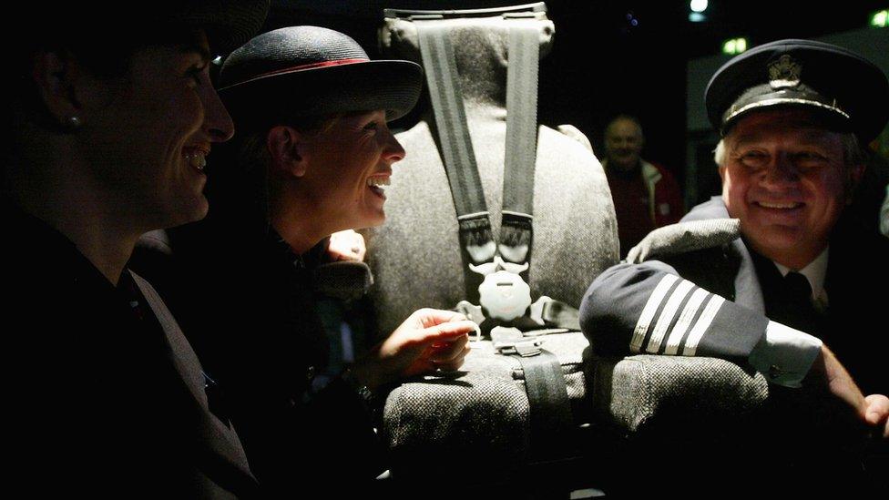 Captain Mike Bannister poses next to the captain's chair with members of the flight crew at the viewing of memorabilia from the recently retired British Airways' Concorde to be auctioned at the Olympia Conference Centre on December 1, 2003 in London.