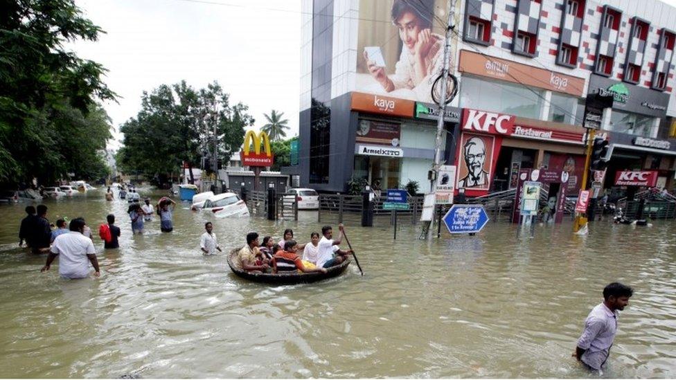 Indian residents make their way through floodwaters in Chennai on December 3, 2015