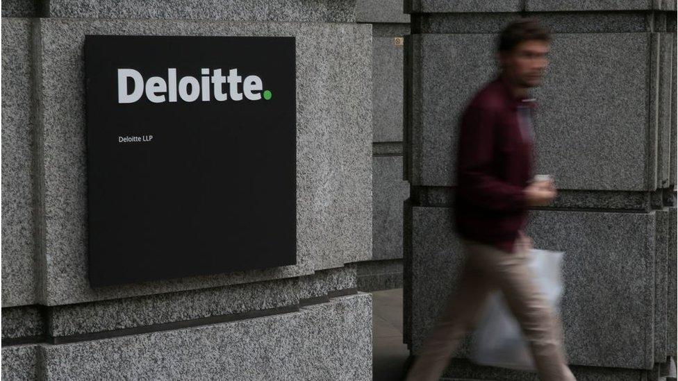 A man leaving Deloitte's offices