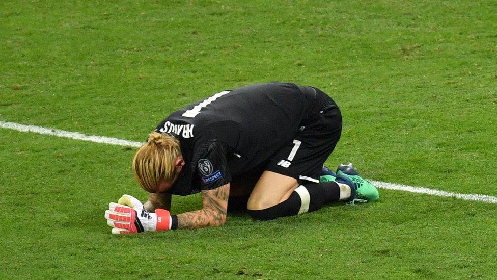 Liverpool goalkeeper Loris Karius drops to his knees on the pitch.