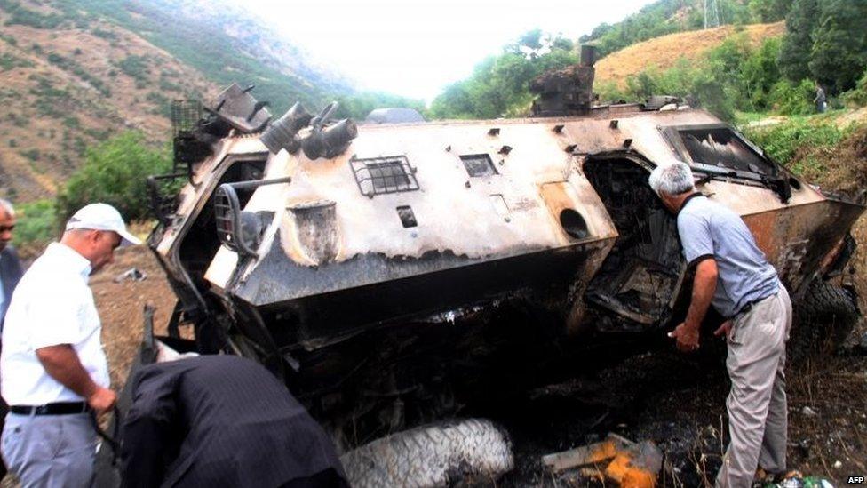 People look at a destroyed armoured vehicle in Daglica, south-eastern Turkey. Photo: 7 September 2015