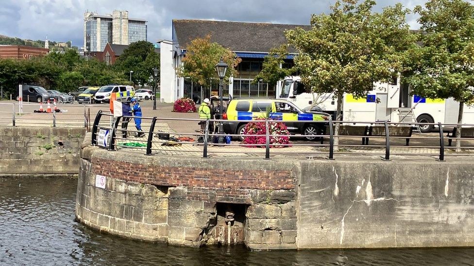 Emergency vehicles and workers near the National Waterfront Museum at Swansea Marina