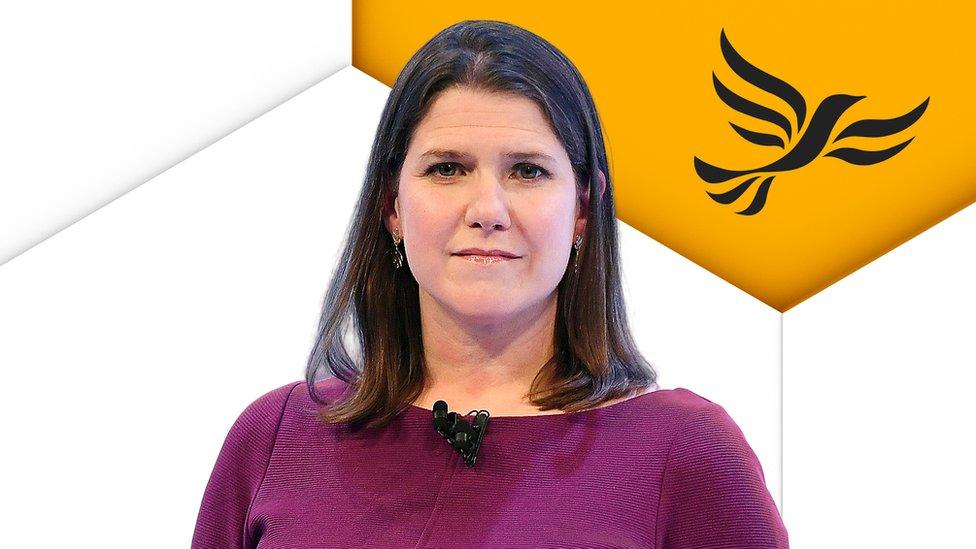 Jo Swinson in front of Lib Dem logo