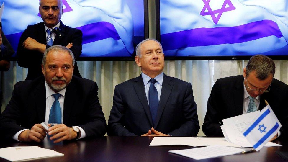 Avigdor Lieberman (L) and Benjamin Netanyahu (C) sign a coalition agreement in Jerusalem (25 May 2016)