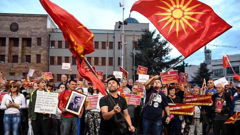 Demonstrators wave flags in front of the parliament building in Skopje on June 23, 2018 during a protest against the new name of the country, the Republic of North Macedonia.