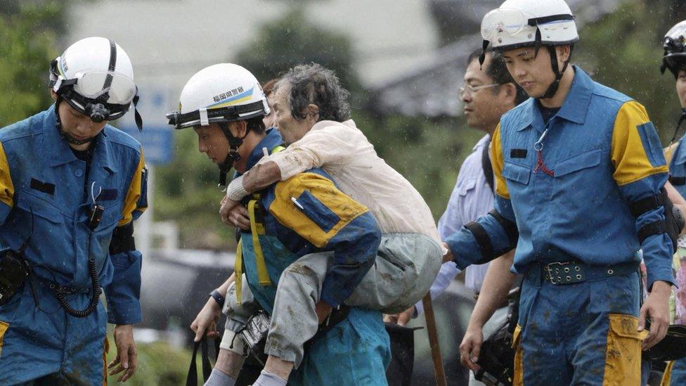 Police officer carries flood victim