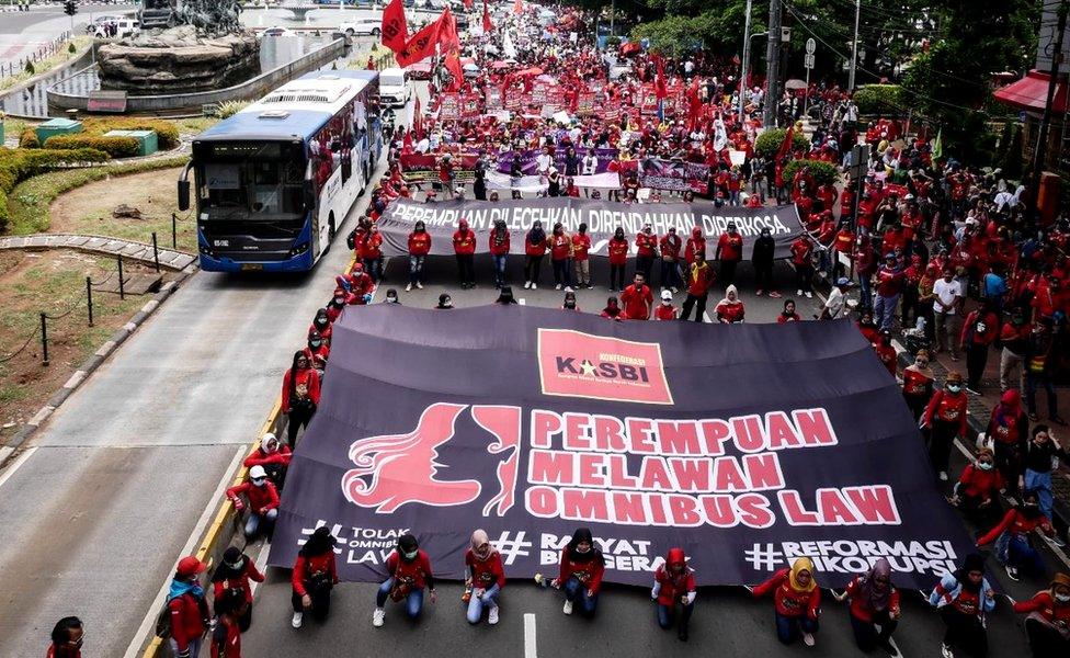 Women carry posters at a march for International Women's Day in Jakarta, 8 March 2020