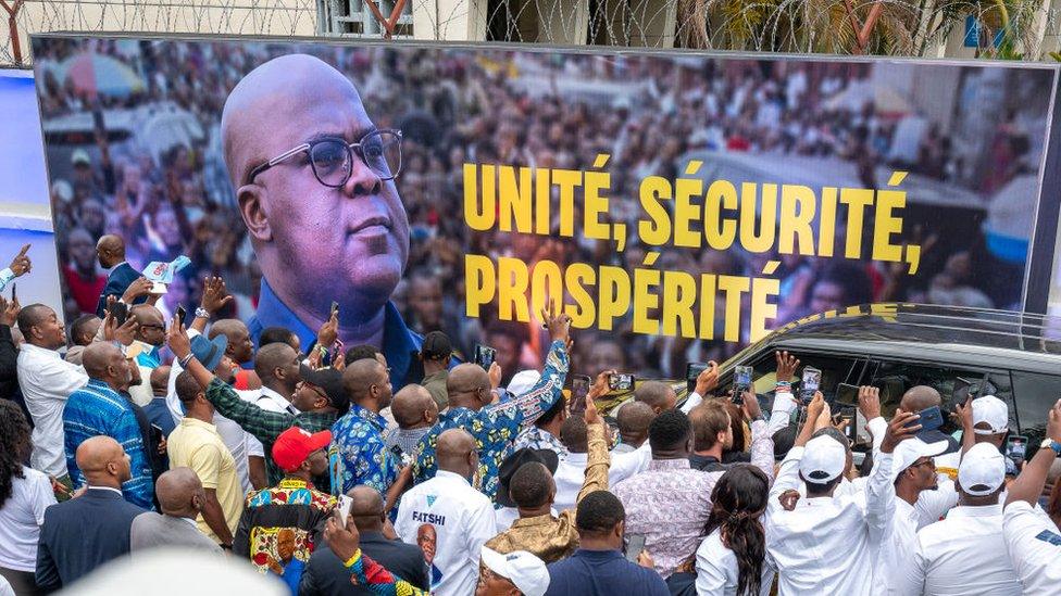 Supporters greet incumbent Democratic Republic of Congo (DRC) President Felix Tshisekedi as he arrives in his motorcade ahead of election results being announced at QG Fatshi 20, the headquarters of his electoral campaign, in Gombe, Kinshasa, on December 31, 2023