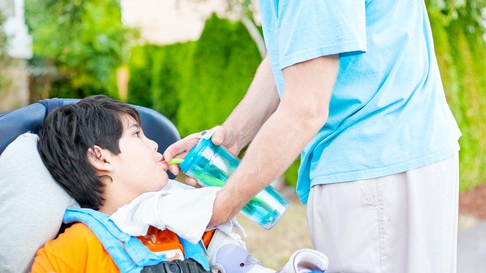 disabled boy drinking through a straw