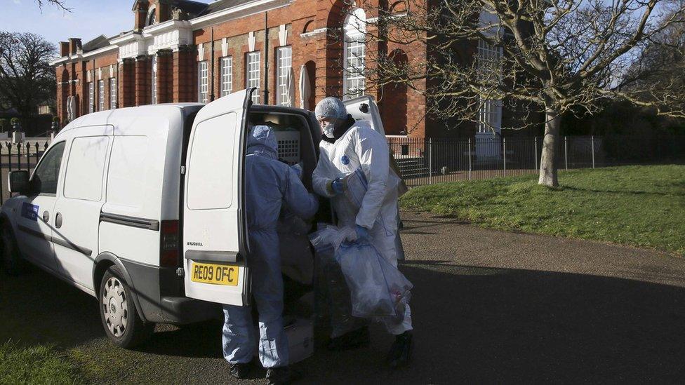 Forensic police officers put evidence into a van in an area near the grounds of Kensington Palace