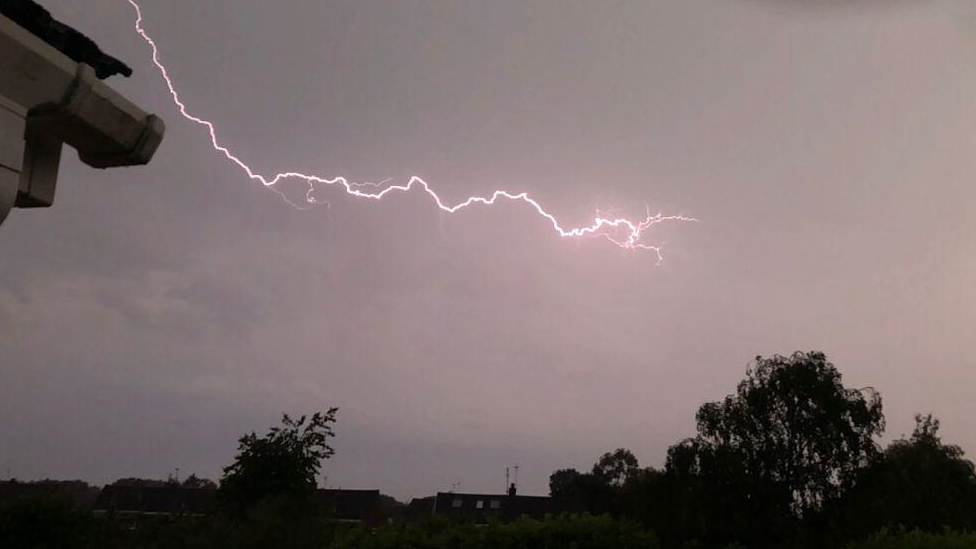 Dark sky with a bolt of lightning flashing across it.