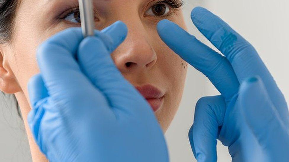 Woman having her nose examined