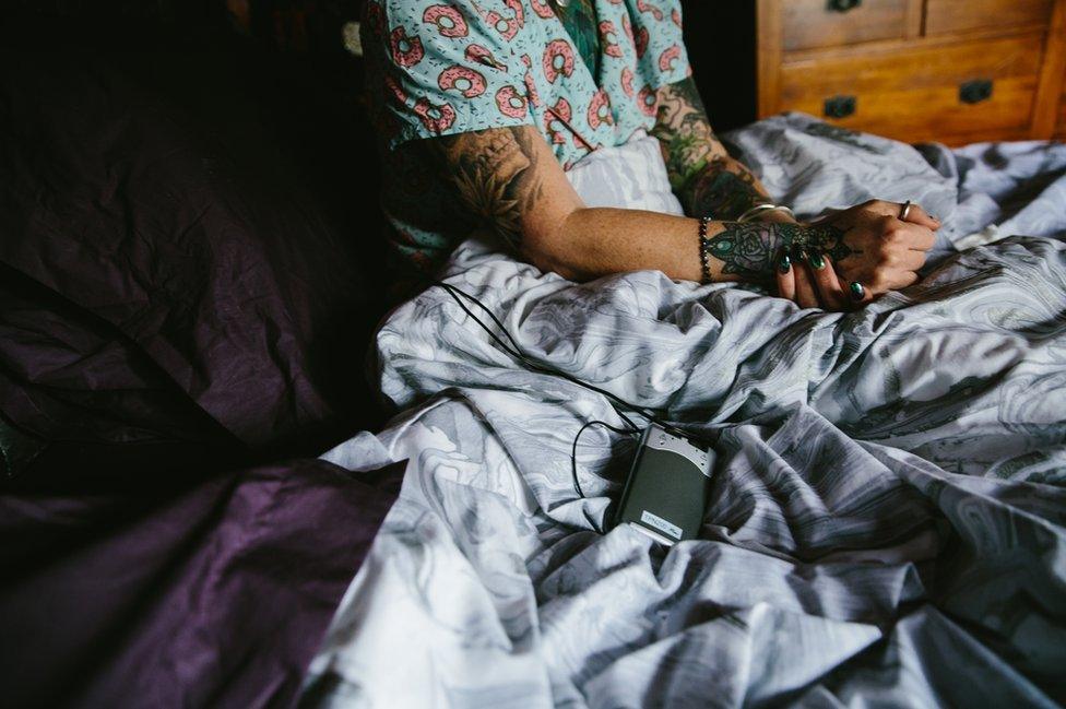 Melanie Semple in bed using a TENS machine