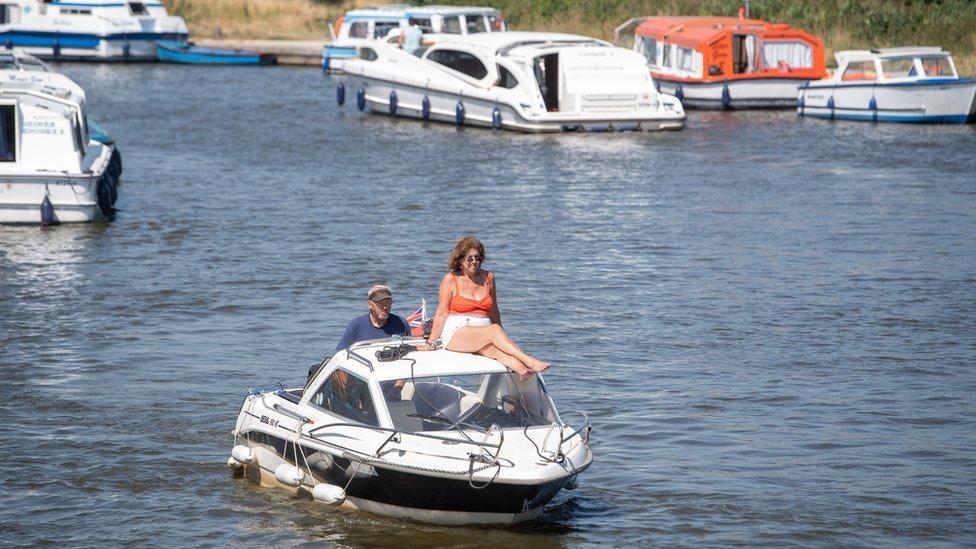 Pleasure boats make their way along the River Ant at Ludham Bridge on the Norfolk Broads