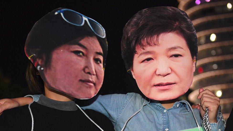 Protestors wear masks of South Korean President Park Geun-hye (right) and her confidante Choi Soon-sil (left) at a rally in Seoul, 27 October 2016