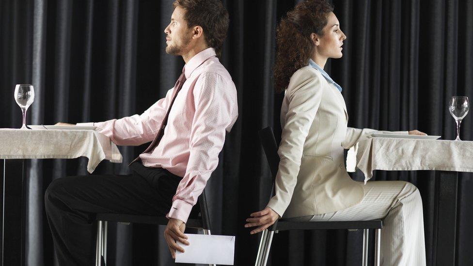 Man passing envelope to woman