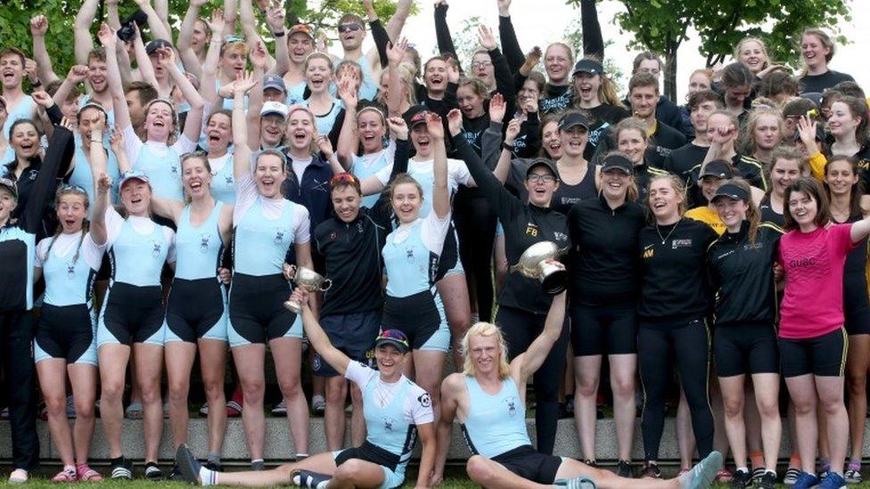 Teams from the University of Edinburgh (light blues) celebrate beating the University of Glasgow (black) in this year's annual boat race