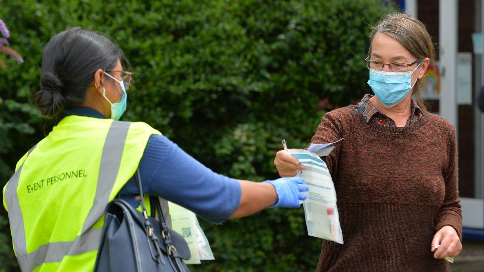 Volunteers hand out testing kits