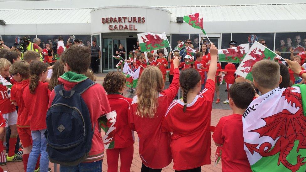 Pupils from Ysgol Treganna wait for the Wales team to arrive at the airport