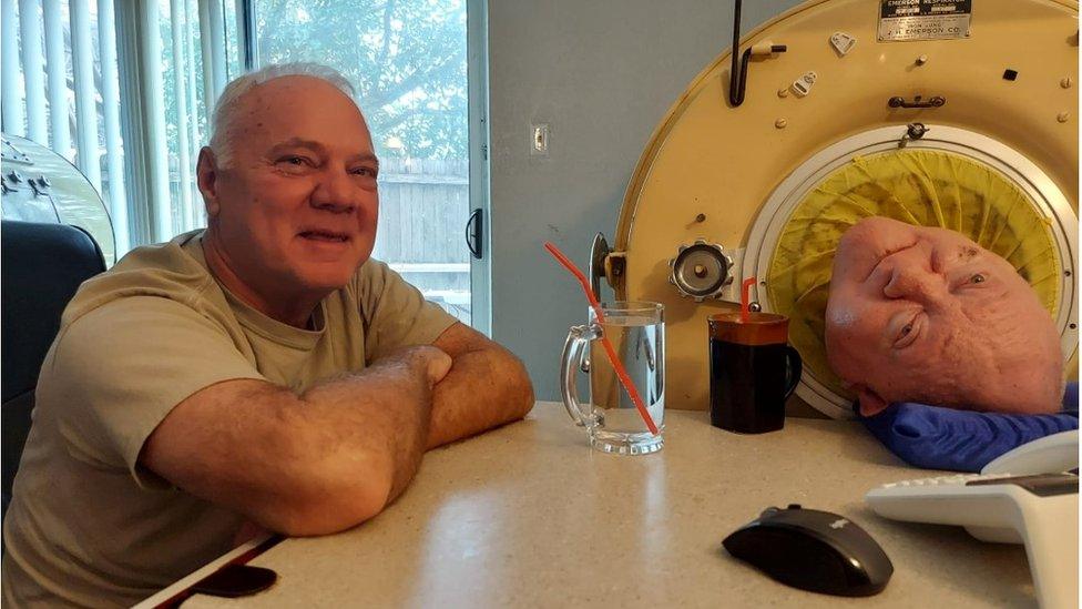 Philip Alexander sitting with his brother Paul, who is lying in his iron lung machine