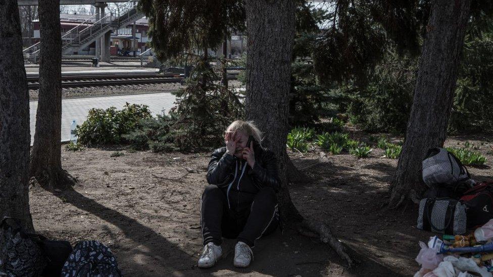 A woman sits down after the attack