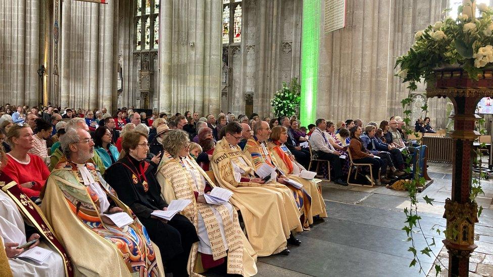 People in Winchester Cathedral watching the Coronation on a big screen