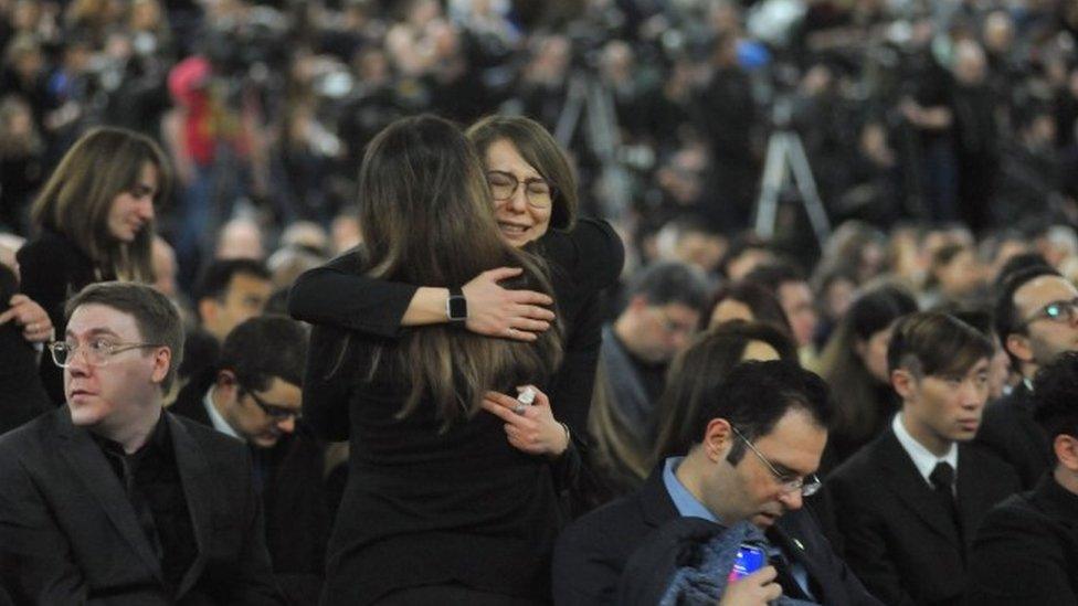 Mourners console each other as they gather at a memorial service for the victims of Ukrainian Airlines flight PS752 crash in Iran