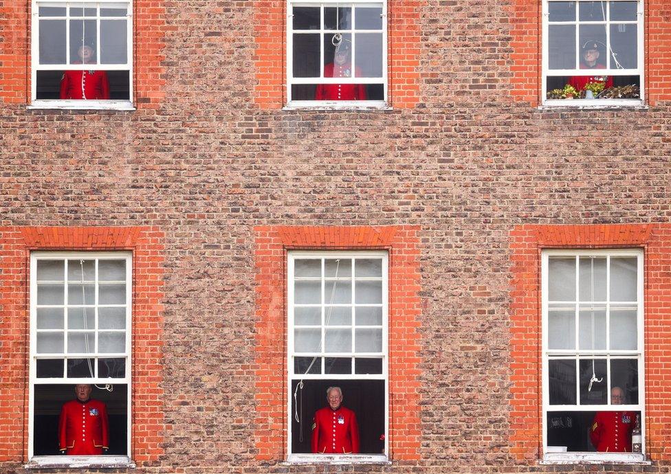 Chelsea pensioners watch a Remembrance Sunday service from their windows at the Royal Hospital Chelsea