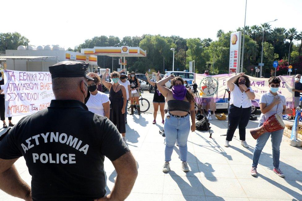 Police on guard as women activists hold up banners as they demonstrate outside the Supreme Court