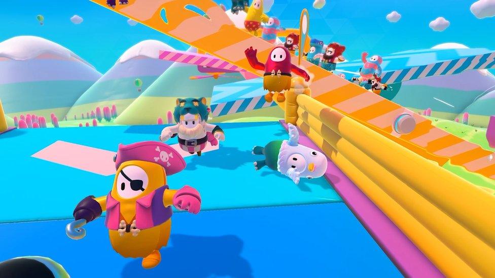 Jellybean-like figures with arms and legs leap through an obstacle course wearing a variety of silly costumes