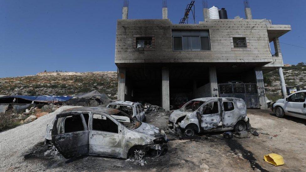 burned building and cars in Mughayir