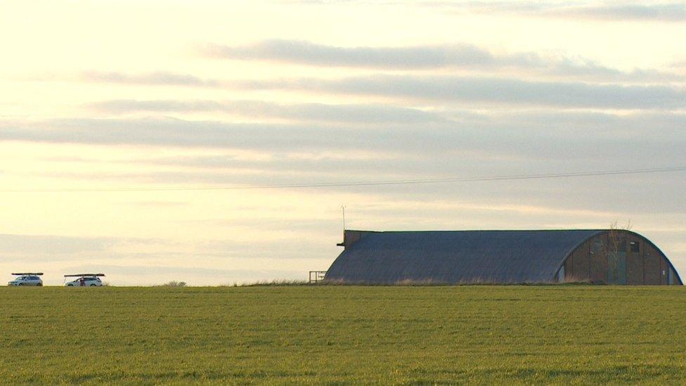 Two vehicles by an airfield