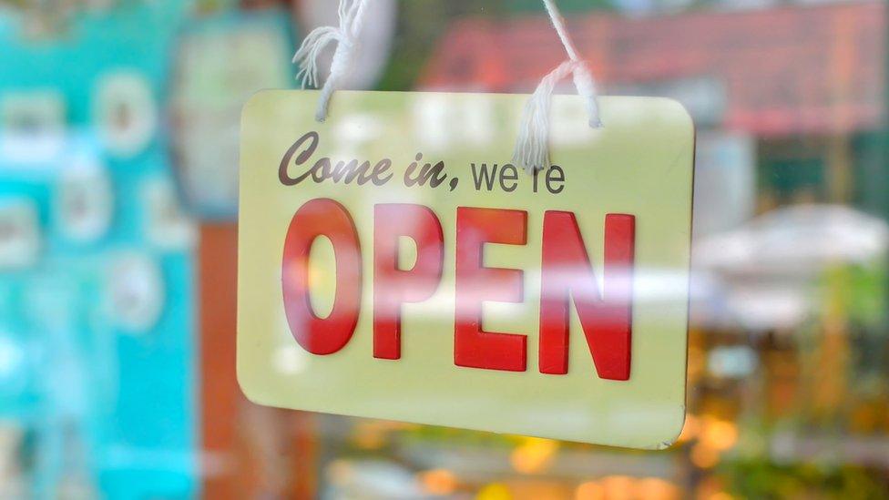 Shop open sign hanging on a door