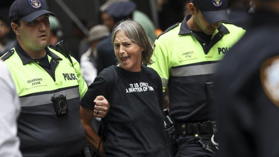 A protestor is arrested by NYPD officers after staging a protest near the Wall Street Bull