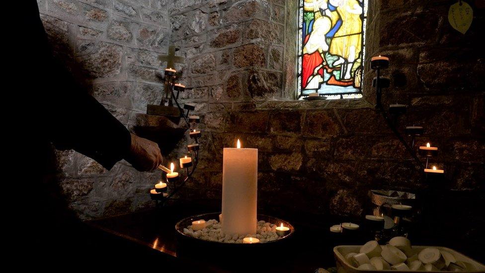 Candles being lit in St Clement Church, Jersey