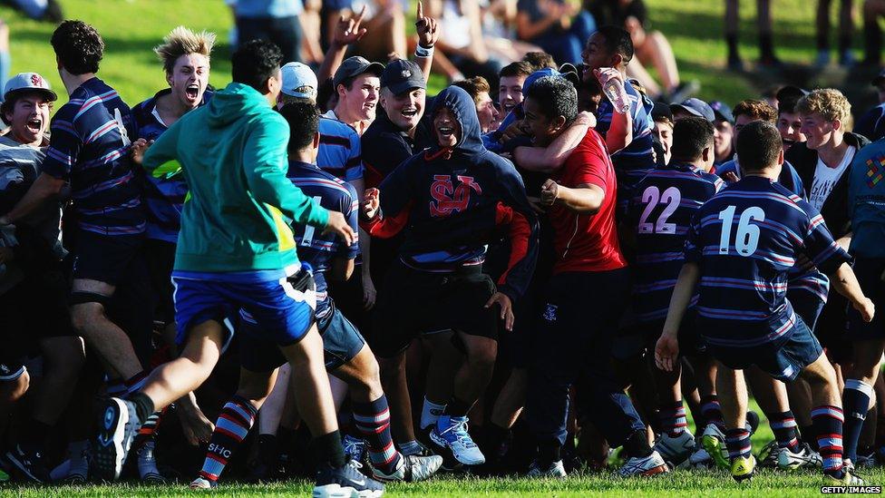 Large group of rugby players celebrating