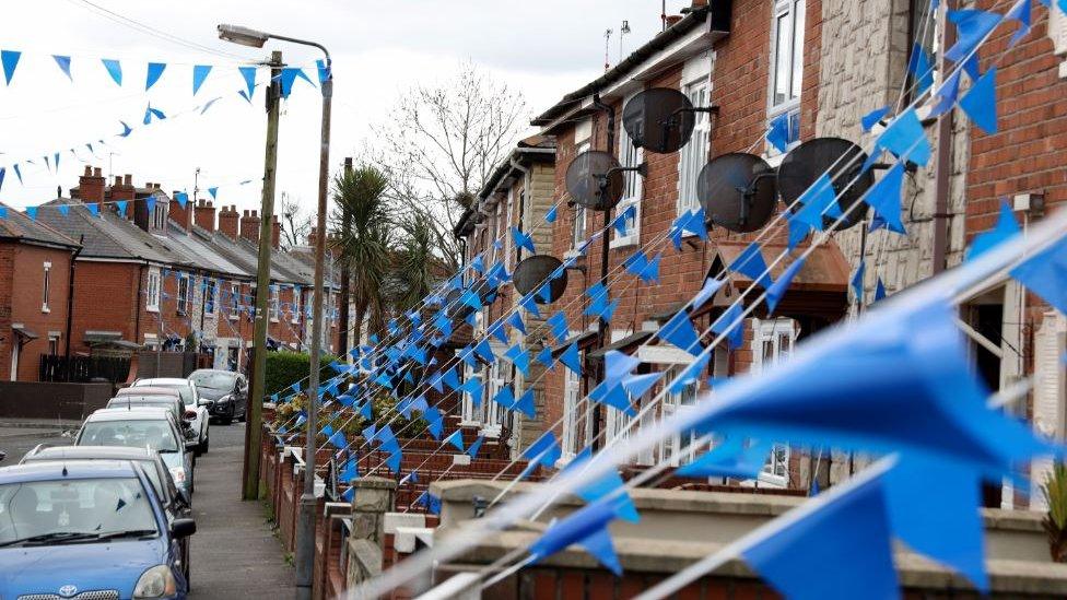 A cluster of streets in west Belfast have been decorated with blue bunting to celebrate the work of the NHS as the coronavirus pandemic worsens