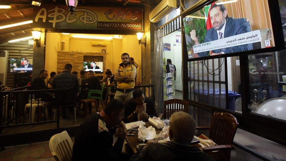 Lebanese watch an interview with Saad Hariri at a coffee shop in Beirut