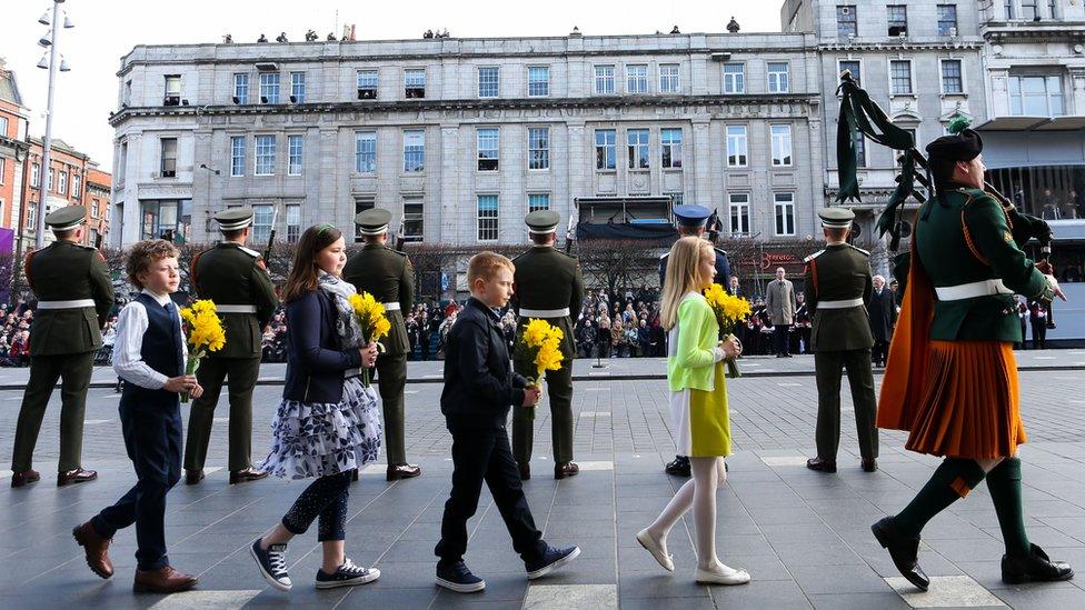 Children carry daffodils outside the GPO in Dublin as part of the Easter Rising centenary commemorations