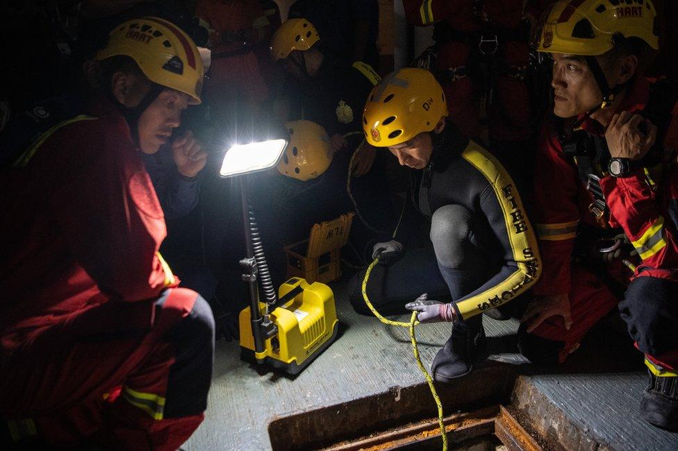 Fire service department personnel inspect a sewer after receiving a report that anti-government protesters had attempted to escape Hong Kong Polytechnic University through the sewage system on November 19, 2019 in Hong Kong, China