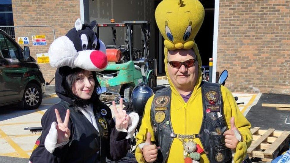 Two people dressed as cartoon characters Sylvester the cat and Tweety the bird