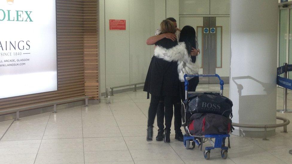 Jamie Harron hugging family members at the airport