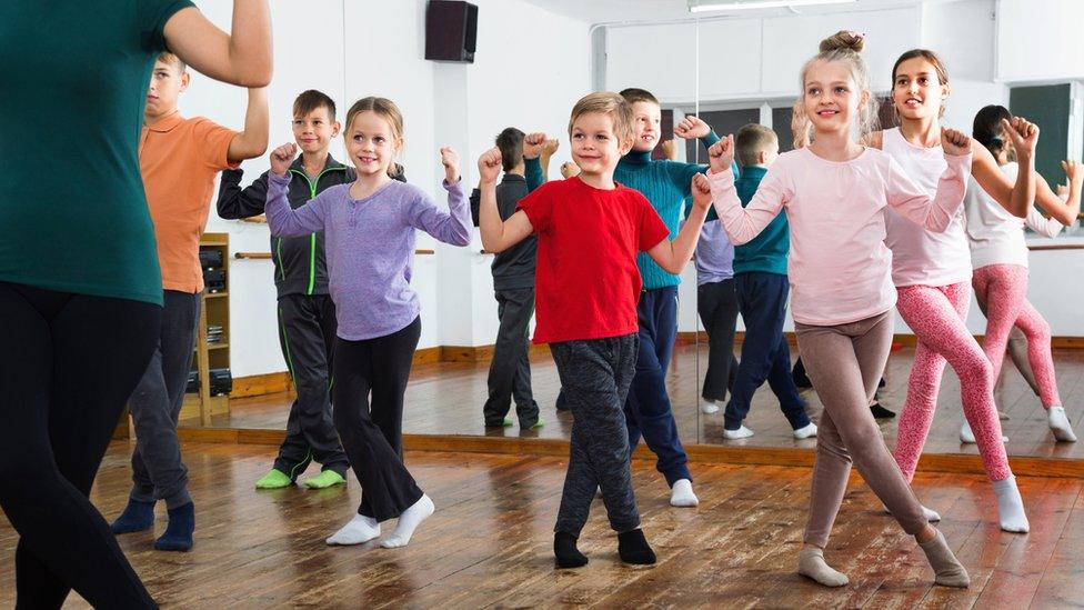 Children take a dance class in a dance studio