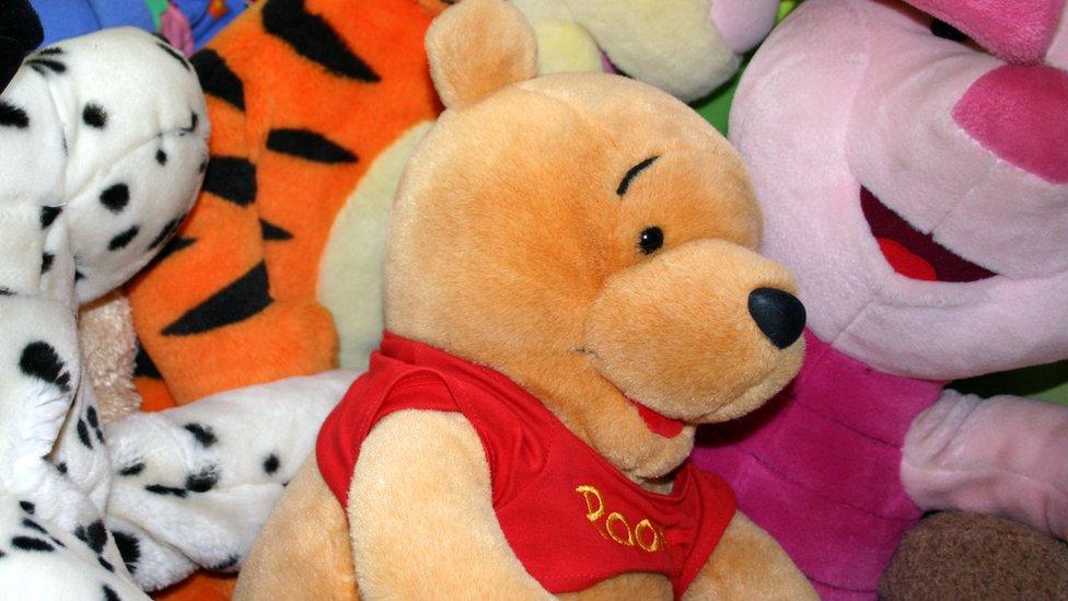 Picture of Winnie-the-Pooh bear among a bunch of cuddly toys